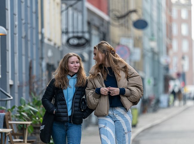 To kvindelige kursister går sammen på gaden og taler