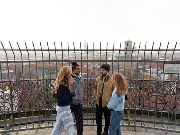 Fire kursister på toppen af Rundetårn med udsigt over byen